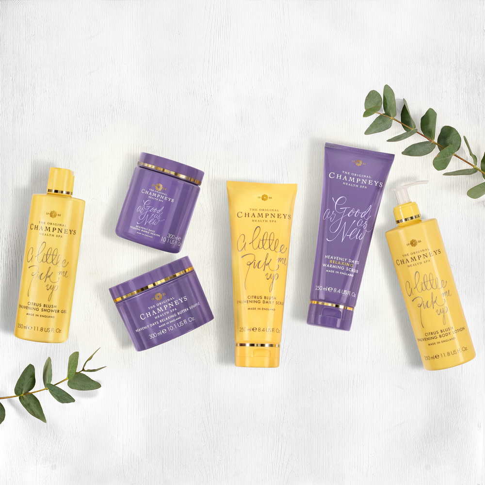 Collection of purple and yellow hair care products with eucalyptus leaves on white background.