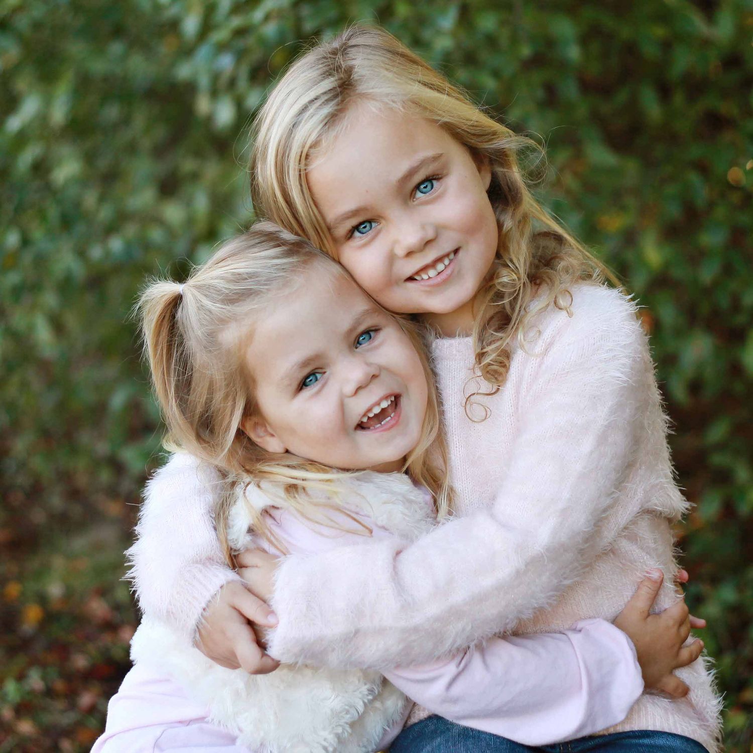 sisters hugging and smiling for preschool photos by victoria leigh photography
