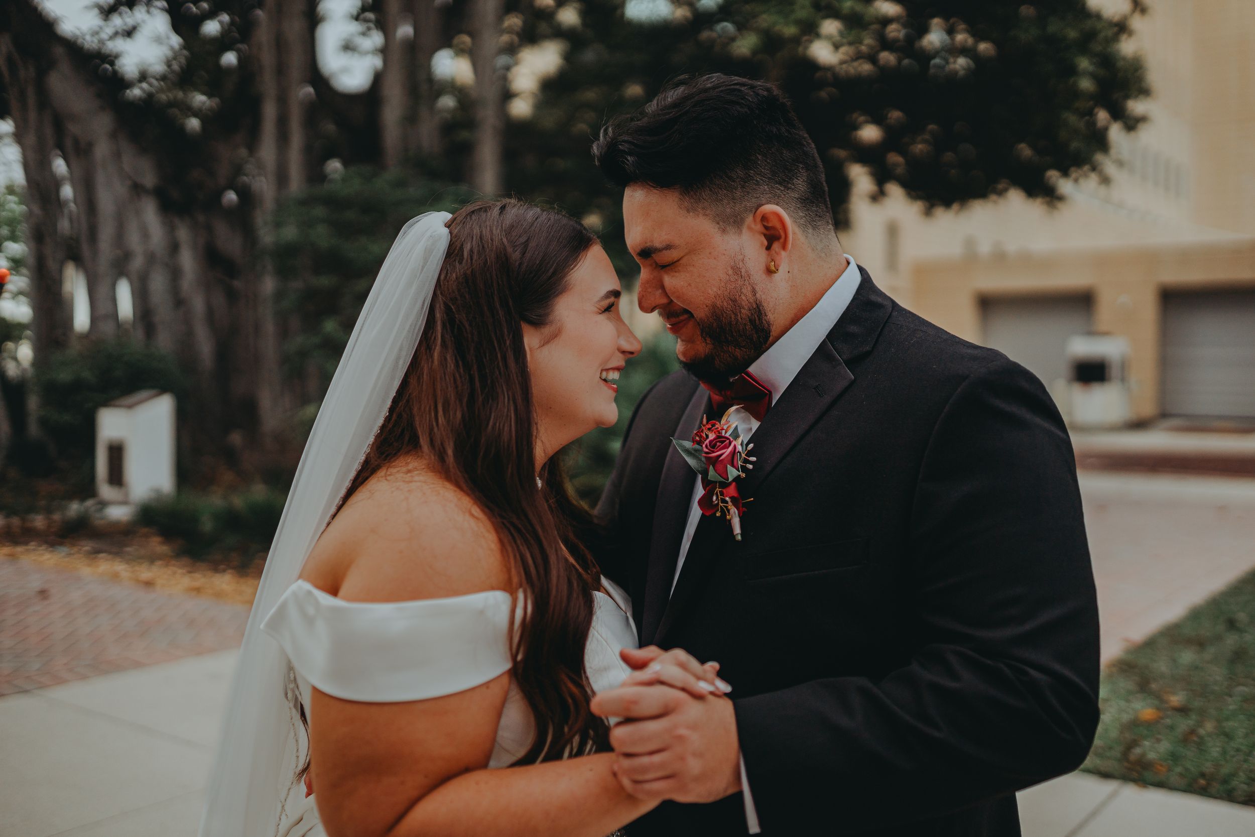 Intimate wedding portrait of couple in formal attire sharing a tender moment.