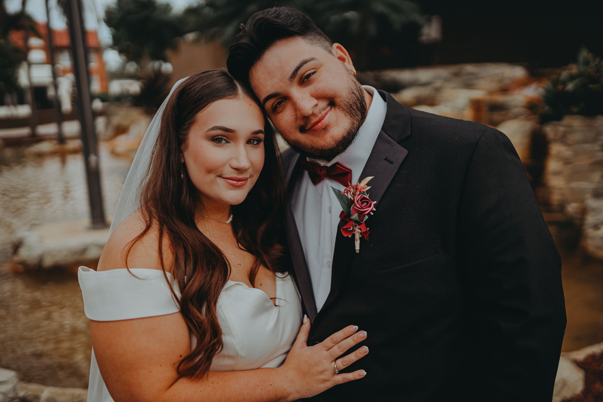 Intimate wedding portrait of couple sharing sweet moment outdoors.