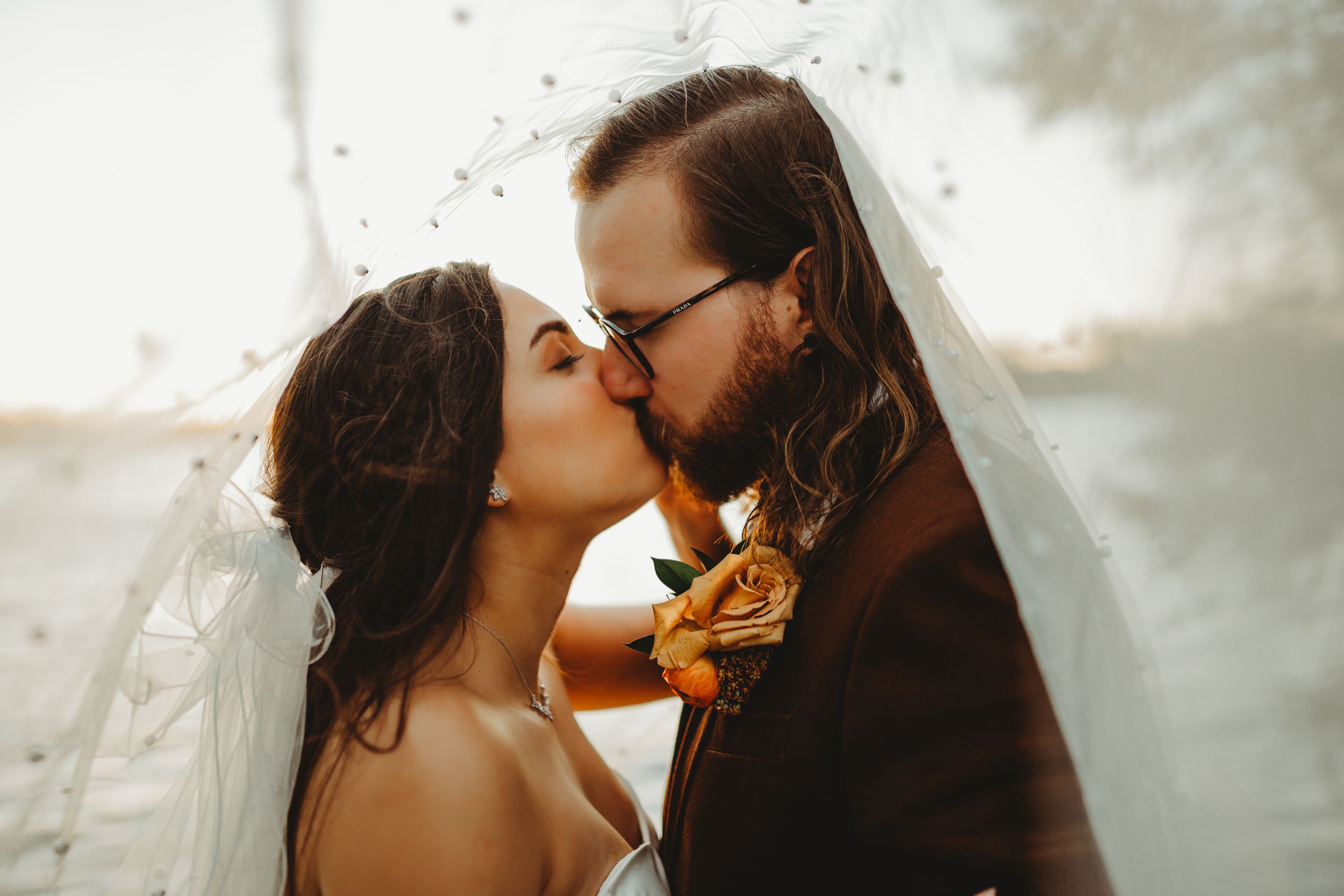Intimate wedding portrait captured during golden hour with lake backdrop.