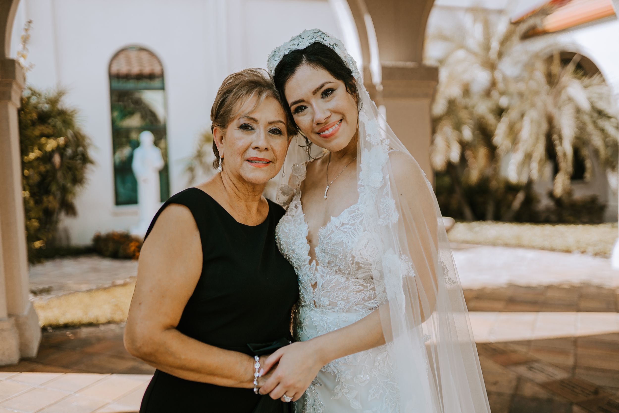 Intimate wedding moment under arched colonnade with ornate architectural details.