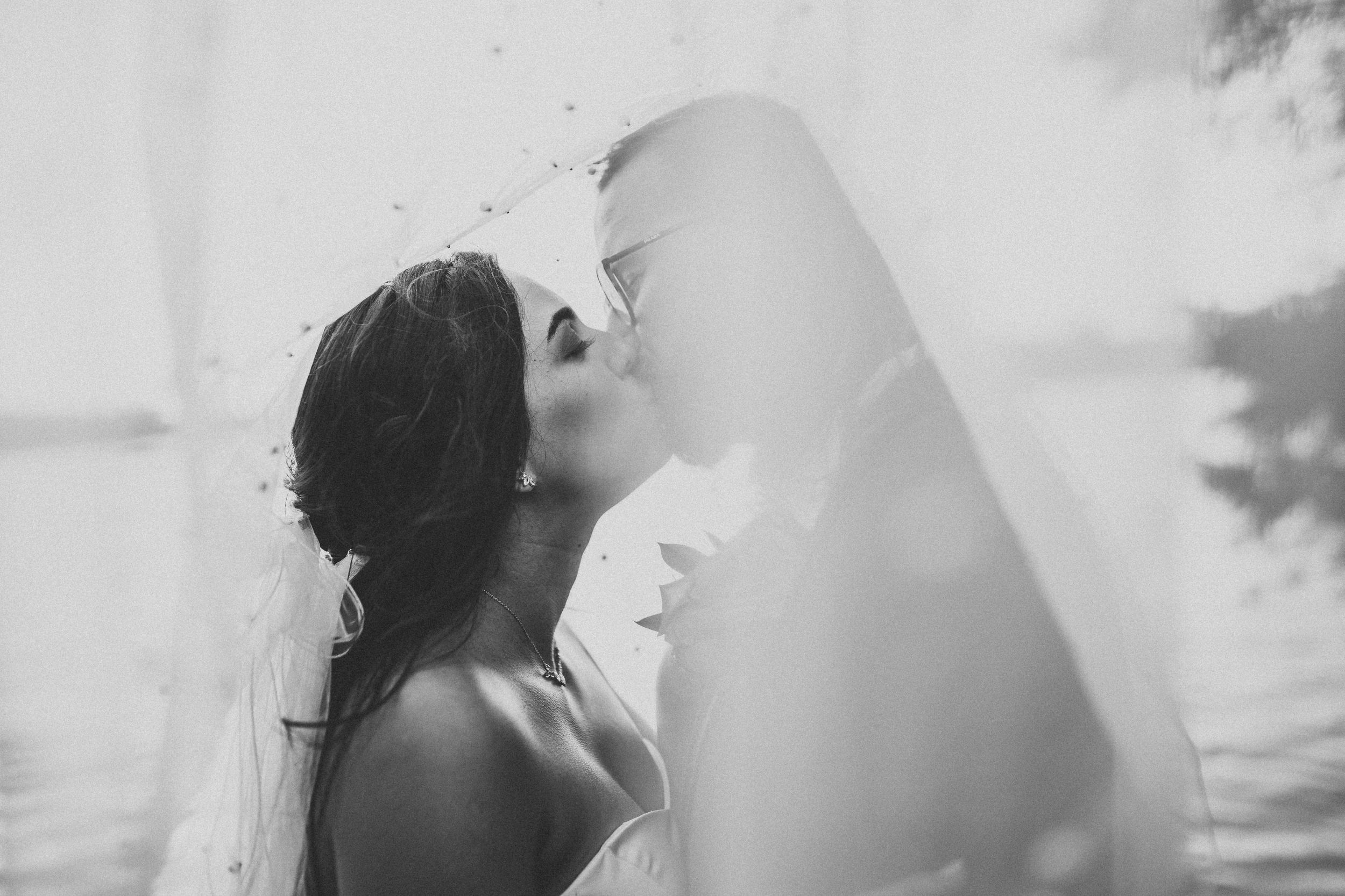 Artistic black and white wedding photo showing couple's tender moment.