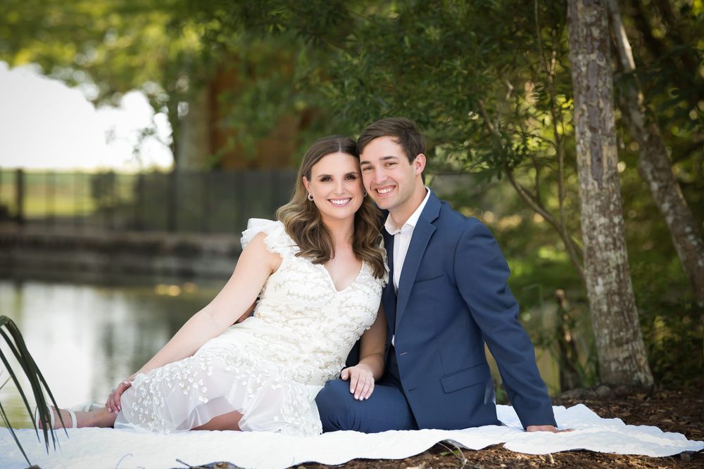 Wedding couple poses together in a sunlit outdoor garden setting.
