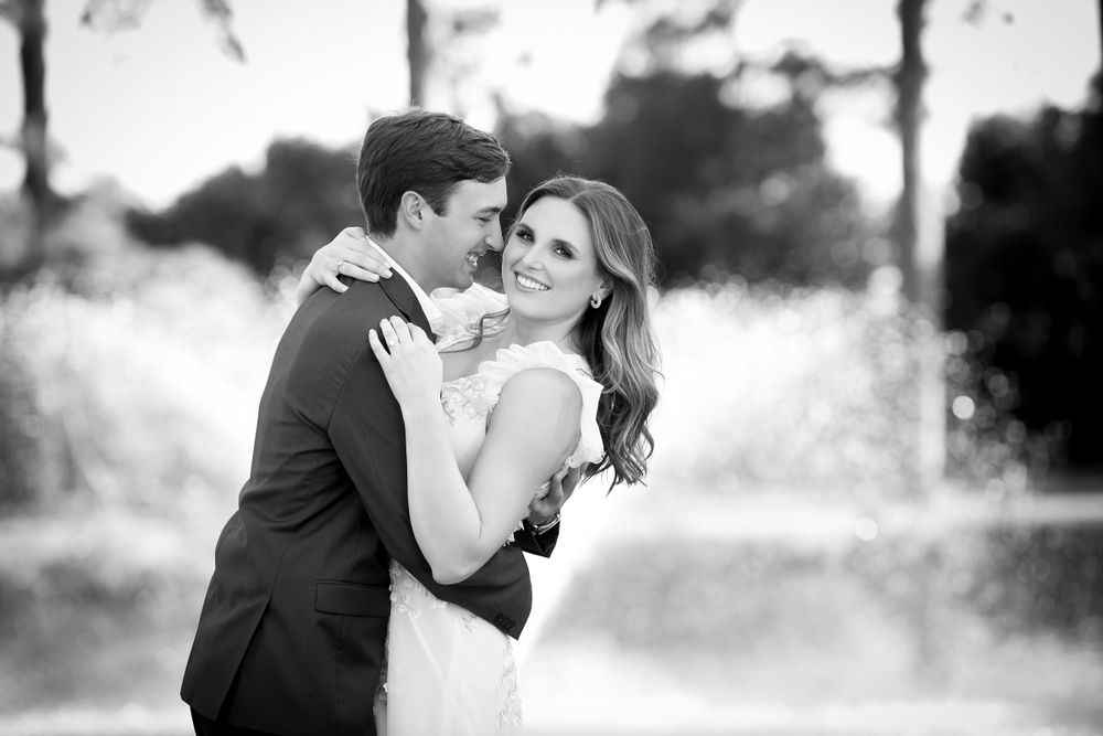 Black and white wedding photos showing romantic moments between a couple in formal attire.