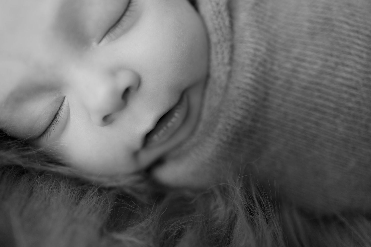 Peaceful sleeping newborn baby details in gentle black and white tones.