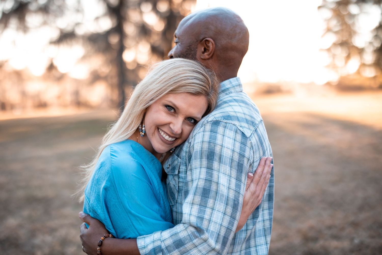 Intimate outdoor portrait of couple embracing during golden hour.
