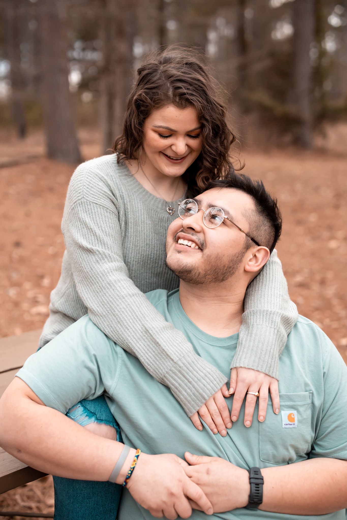 Couple shares intimate moment while sitting together in casual attire outdoors.