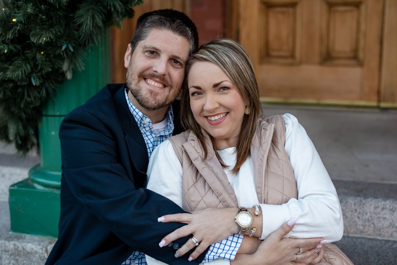 A romantic couple shares tender moments against a brick building exterior in a series of candid shots.