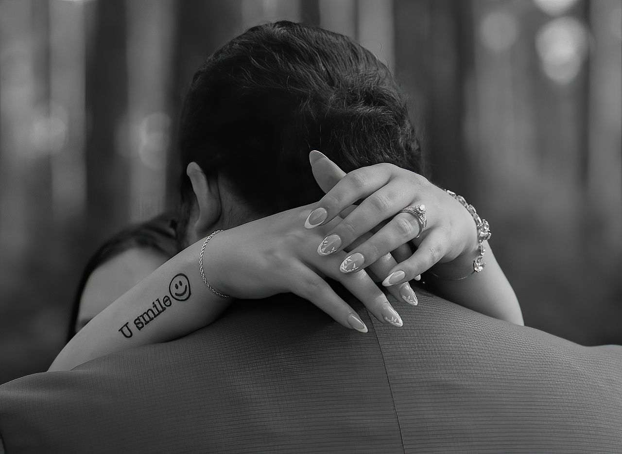 Black and white close-up shots focusing on embracing hands and shoulders.