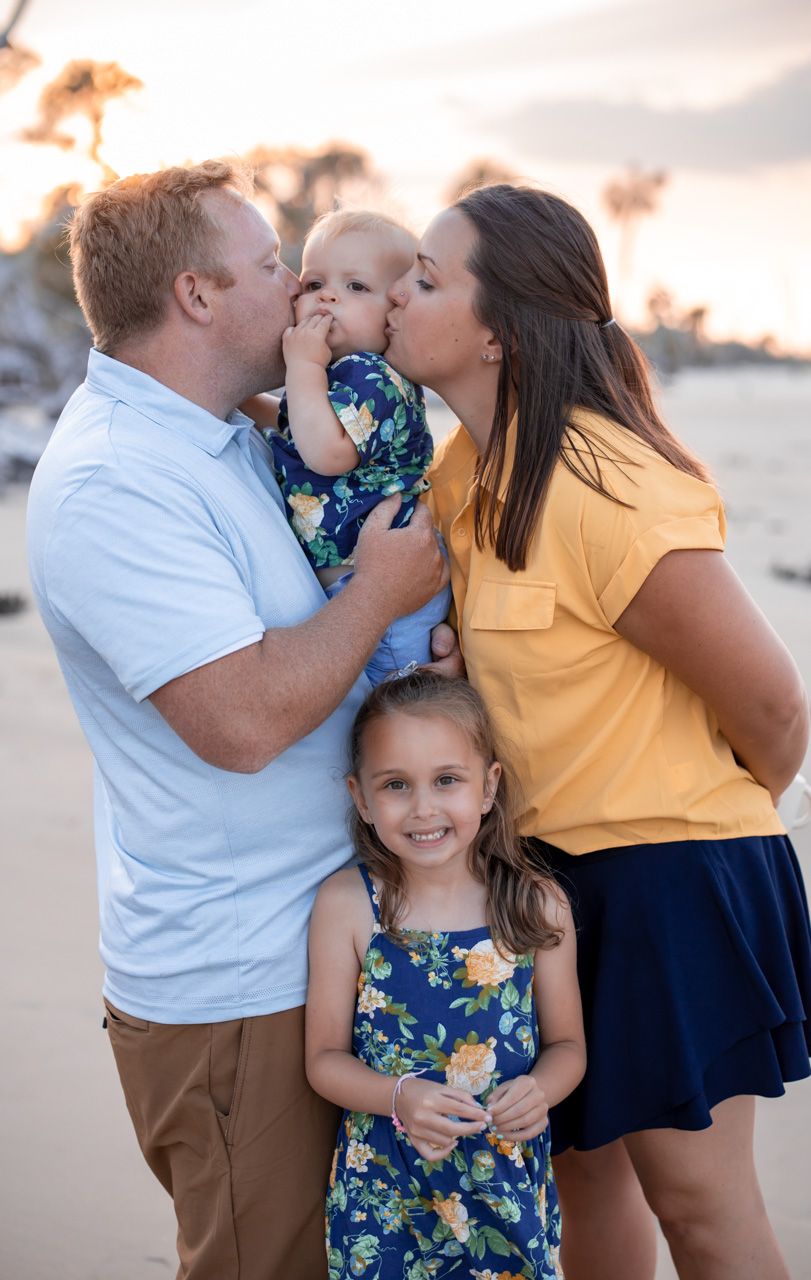 Sweet family moment at sunset with coordinating blue and yellow outfits.