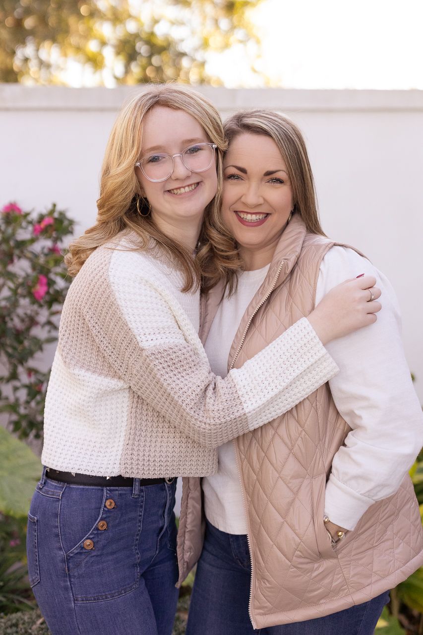 Lifestyle portraits with cream knit sweaters and casual denim in an outdoor garden setting.