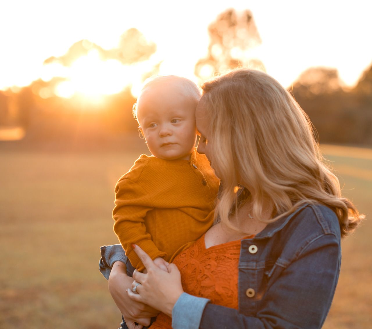 Sunset photoshoot featuring tender moments between parent and child in warm golden light.