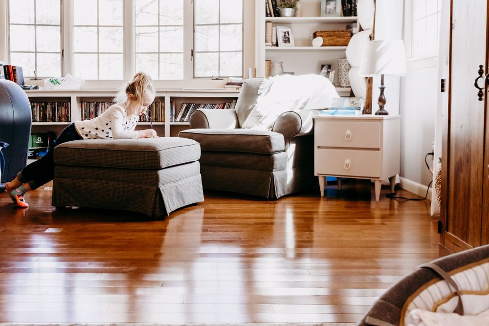 Bright living room with leather armchairs and hardwood floors near built-in bookshelves.
