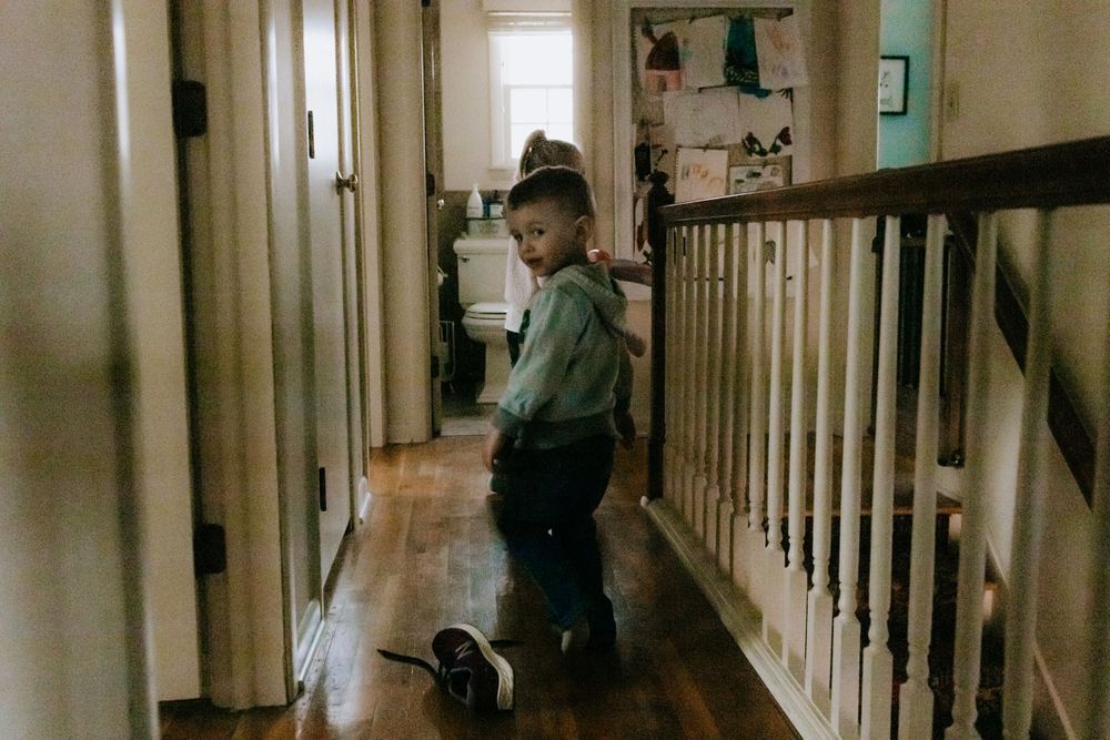 A dimly lit hallway with white railings and hardwood flooring.