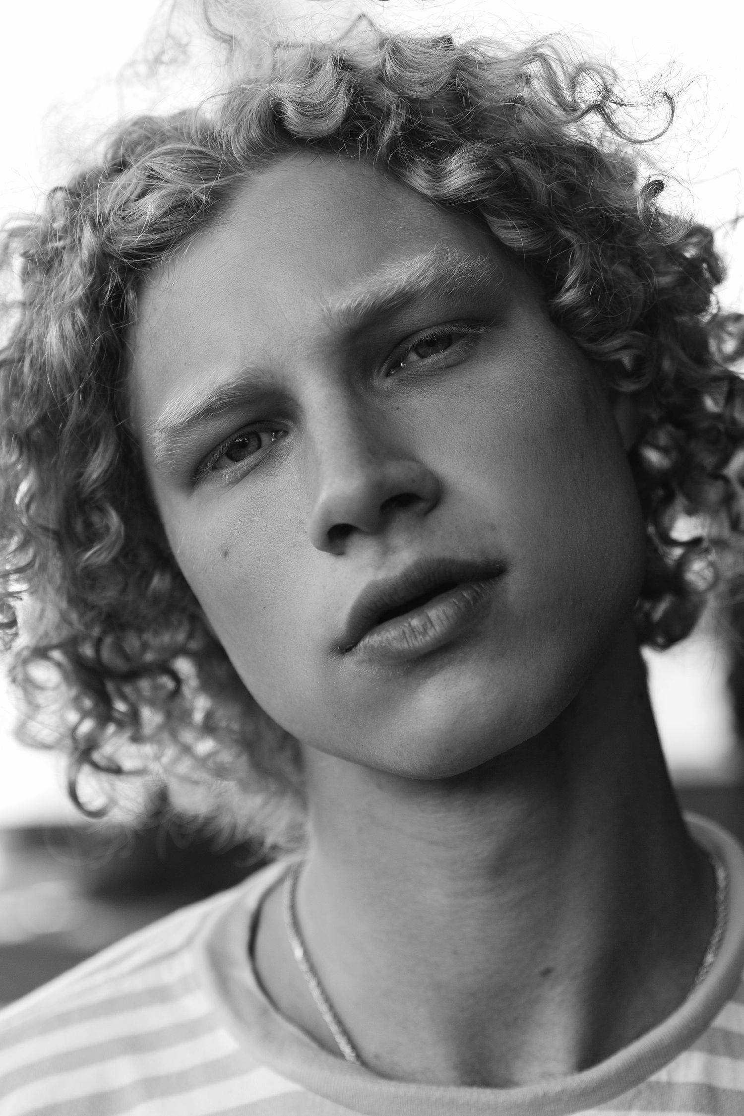 Black and white portrait of curly blonde male editorial model, San Clemente beach fashion editorial