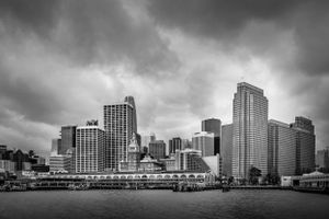 Moody cityscape of San Francisco's waterfront under dark clouds.