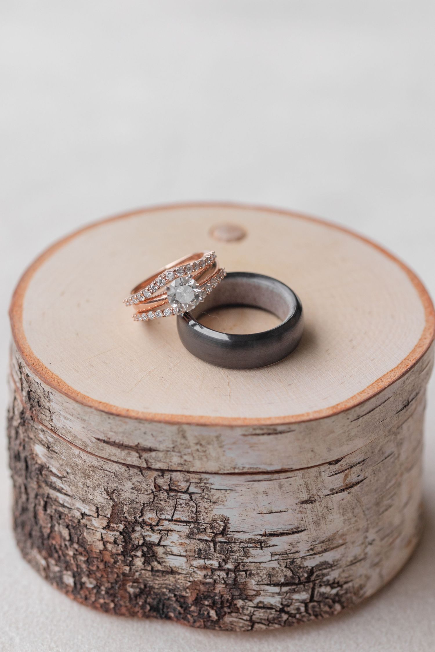 Wedding rings displayed on rustic birch wood slices.