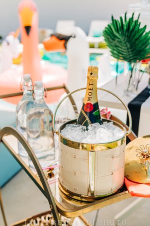 Moet champagne bottle chilling in ice bucket with party decorations and glassware.