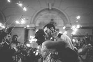Black and white wedding reception dance with sparklers creating magical atmosphere.