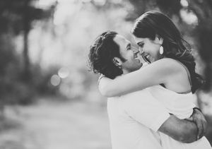 Black and white portrait of joyful couple sharing intimate embrace outdoors.