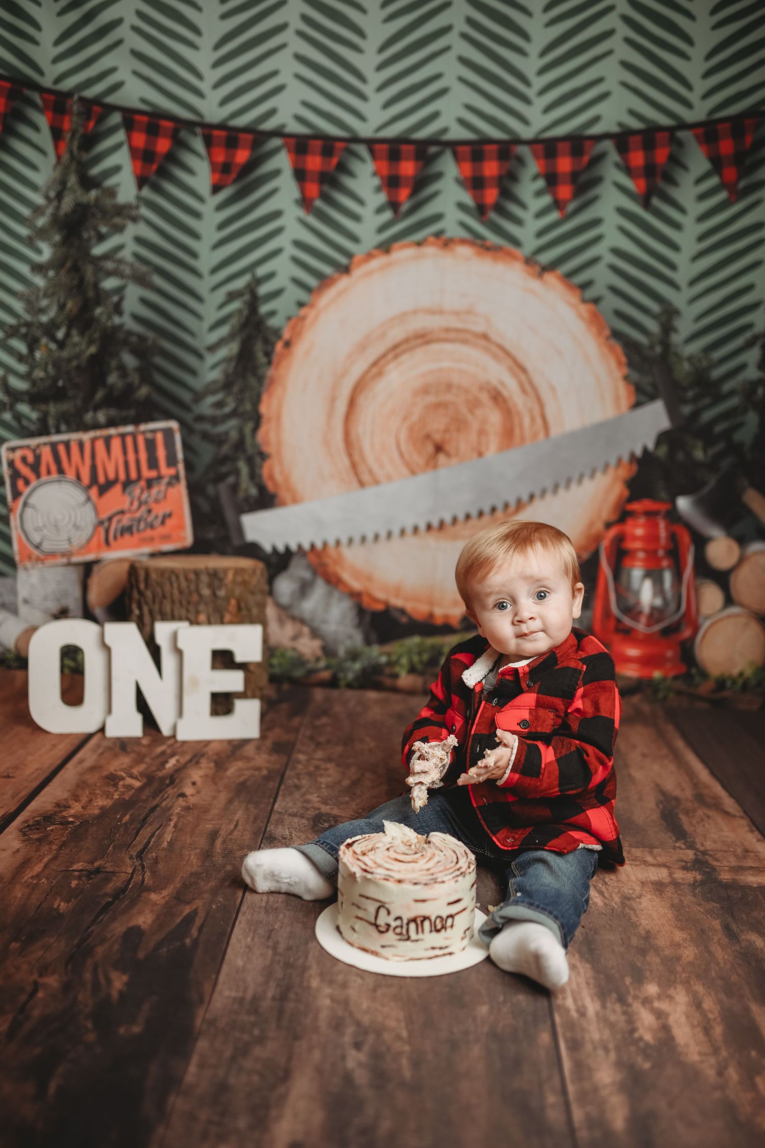 Rustic lumberjack themed first birthday party setup with wood slices and buffalo plaid decor.