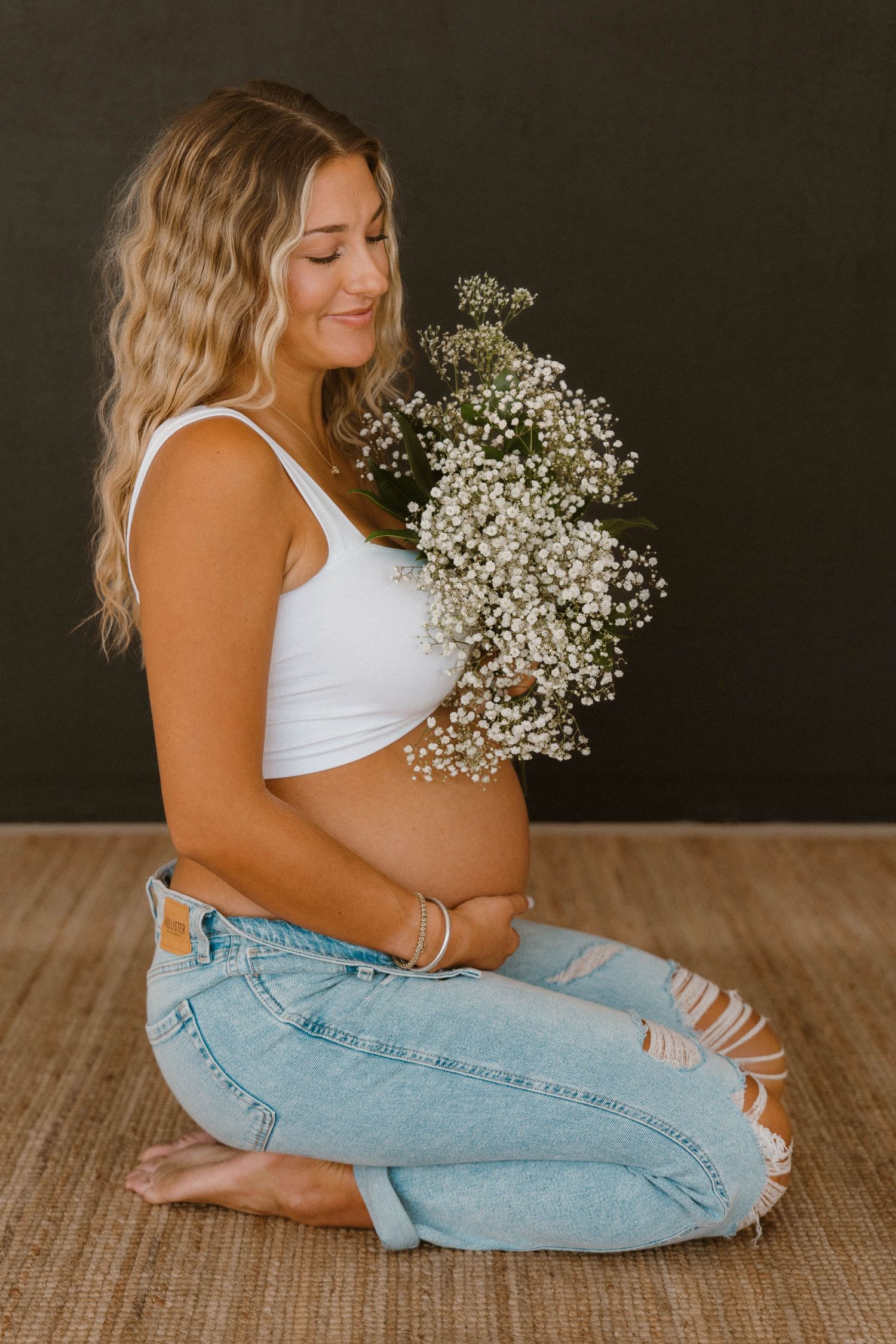 Maternity session in Denton Texas. Photograph of a woman looking at flowers and pregnant.