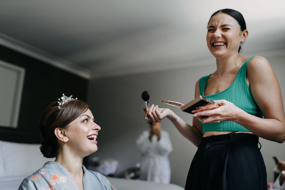 Two people share a joyful moment during wedding preparations.