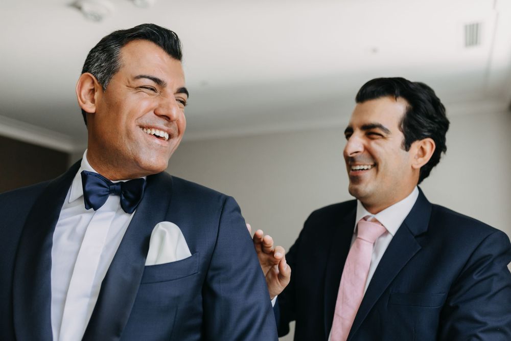 Two people in suits sharing a candid laughing moment.
