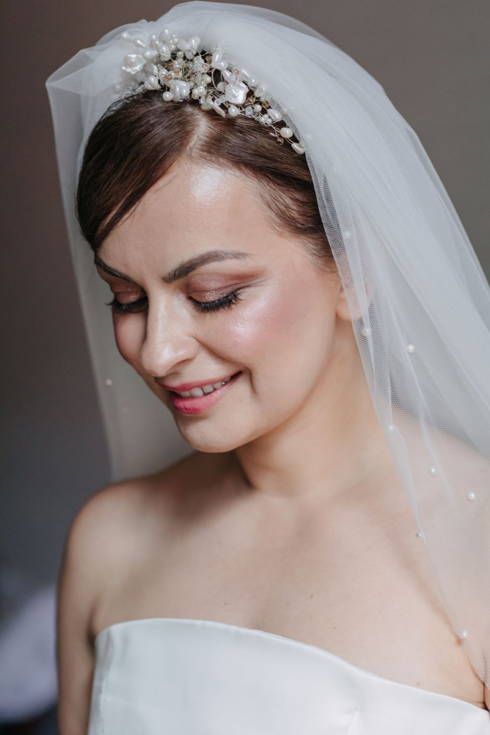 Elegant bridal portrait showcasing a delicate pearl headpiece and flowing veil.