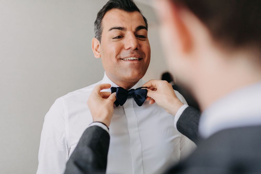 Getting ready moment as bow tie is adjusted before the ceremony.