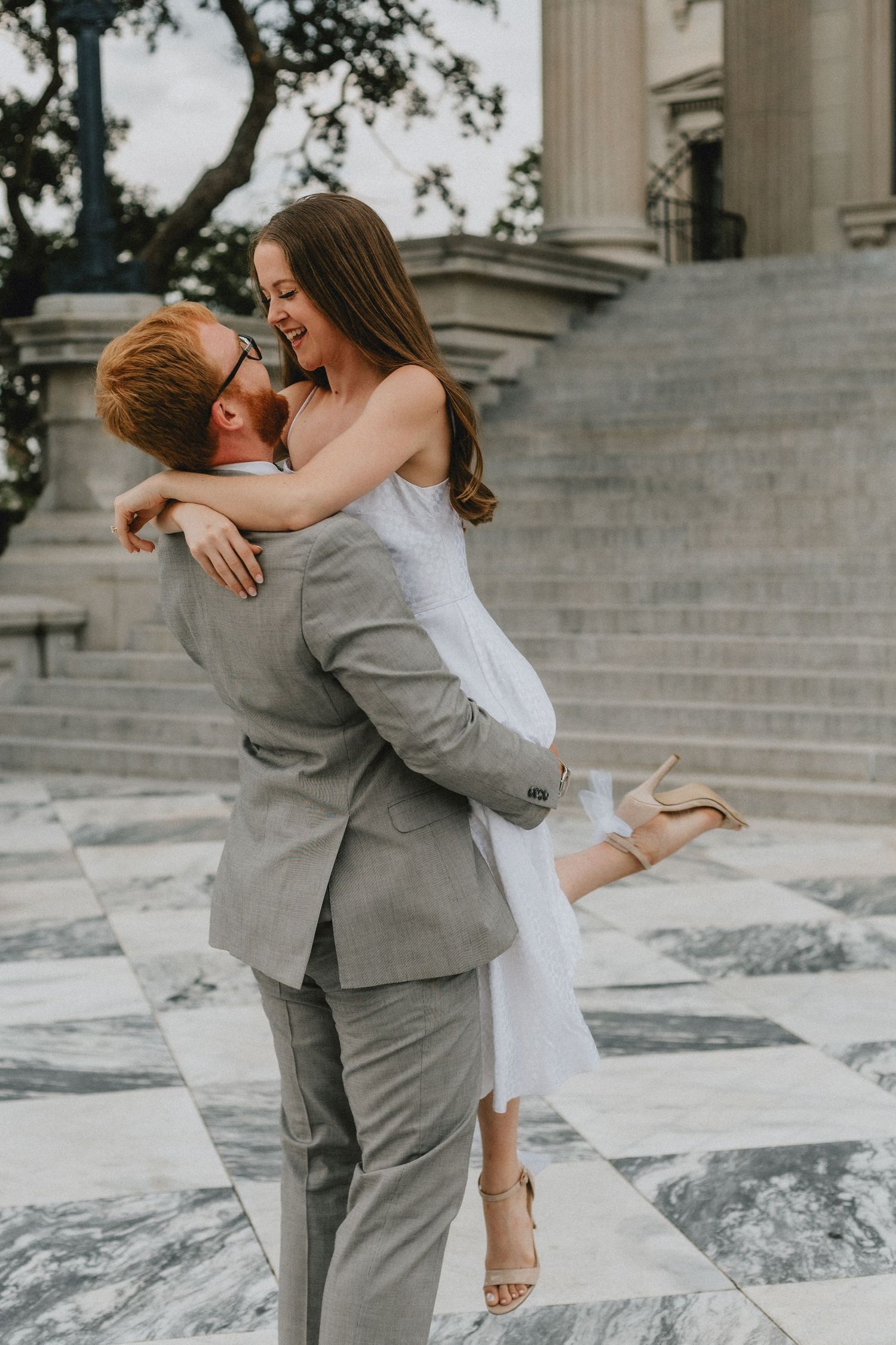 A man is picking up a woman and twirling her