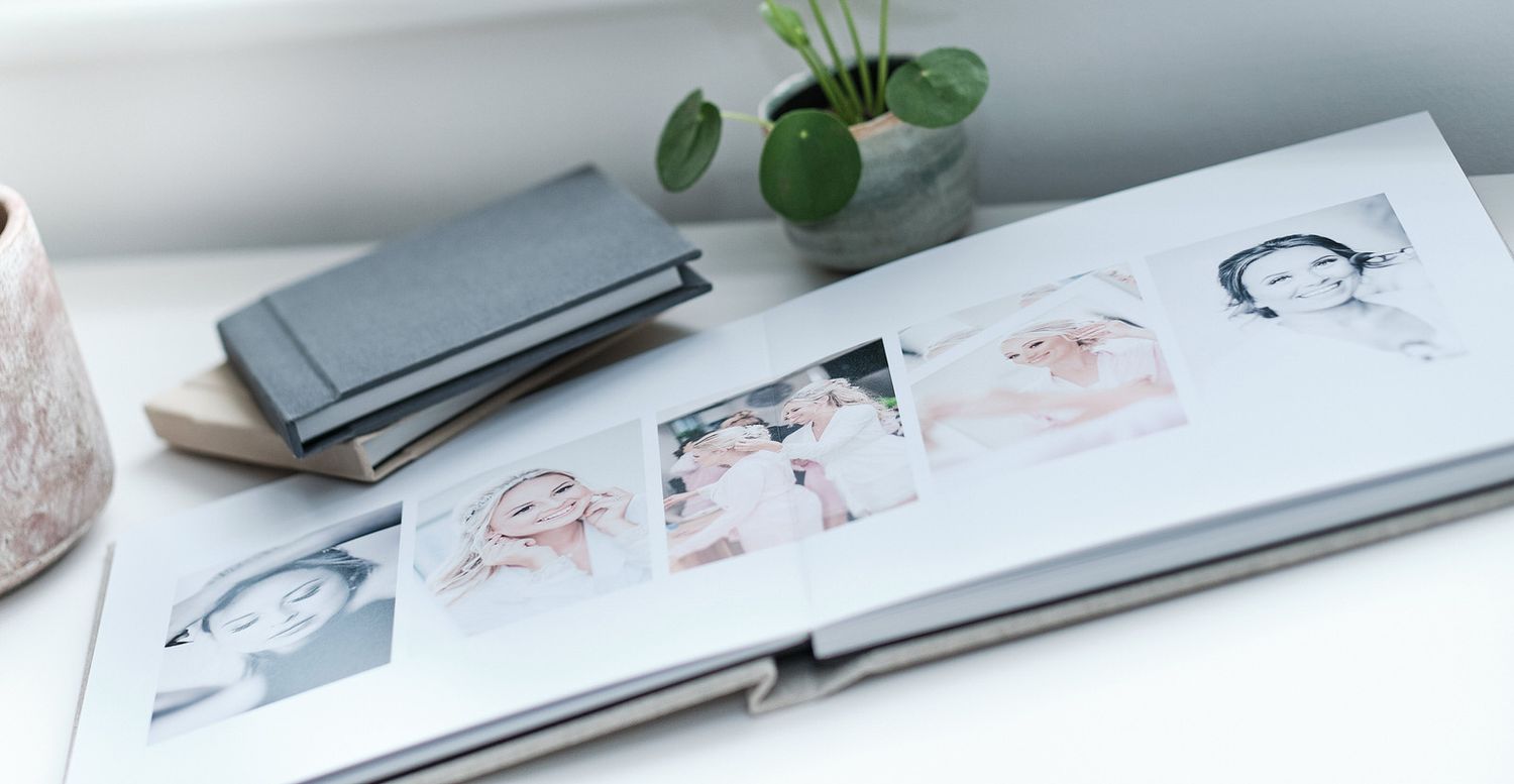 An open photo album displaying a series of portrait sketches on white pages.