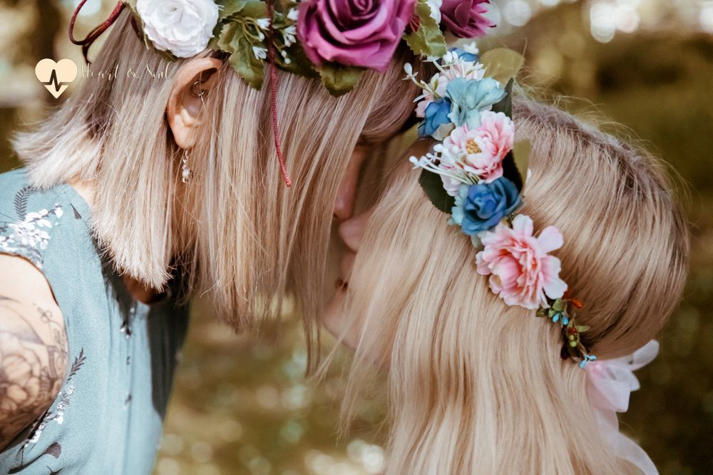 lady and girl noses touching wearing flower headbands