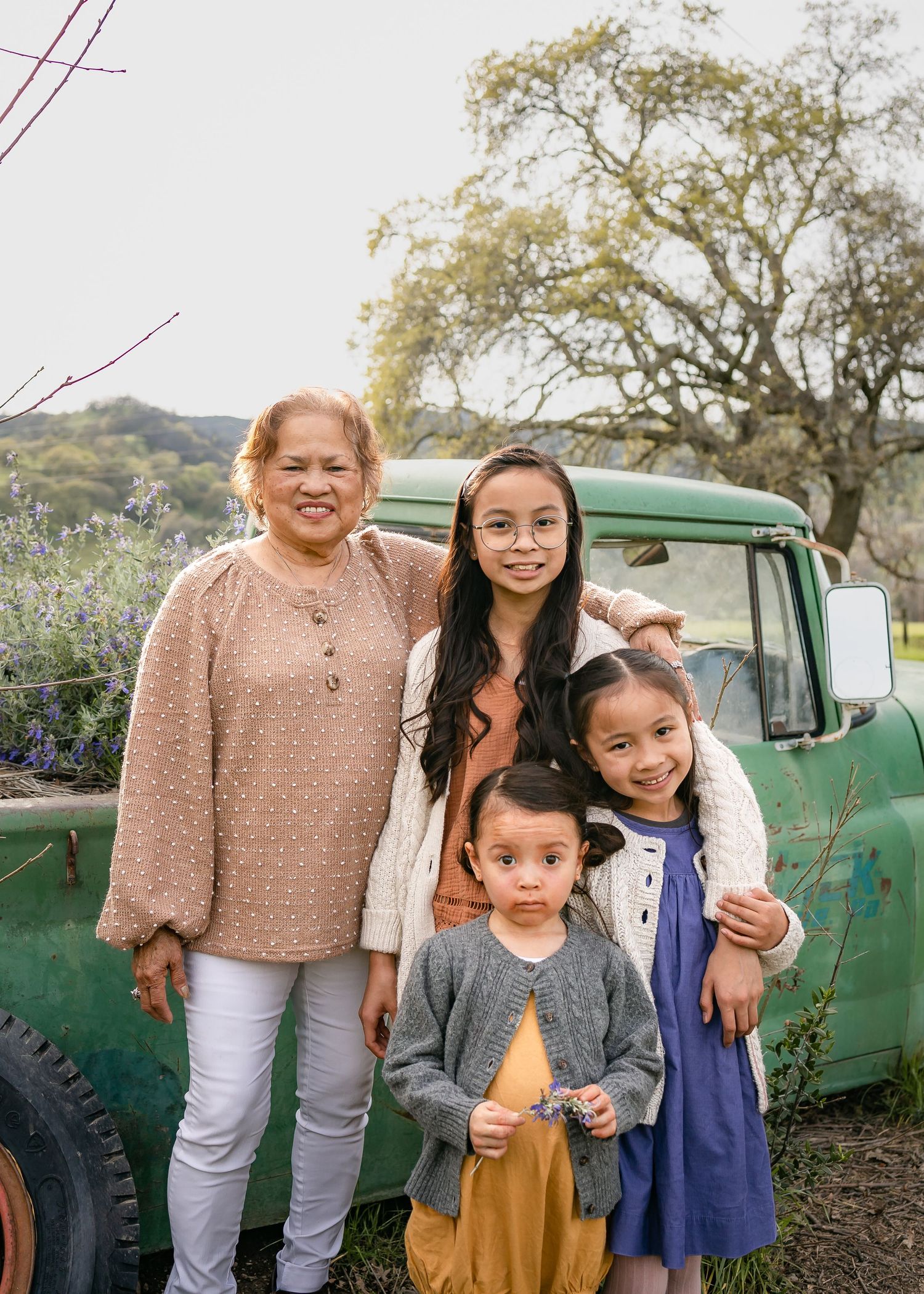 Grandma and granddaughters pose in front of rustic truck at Soul Food Farm