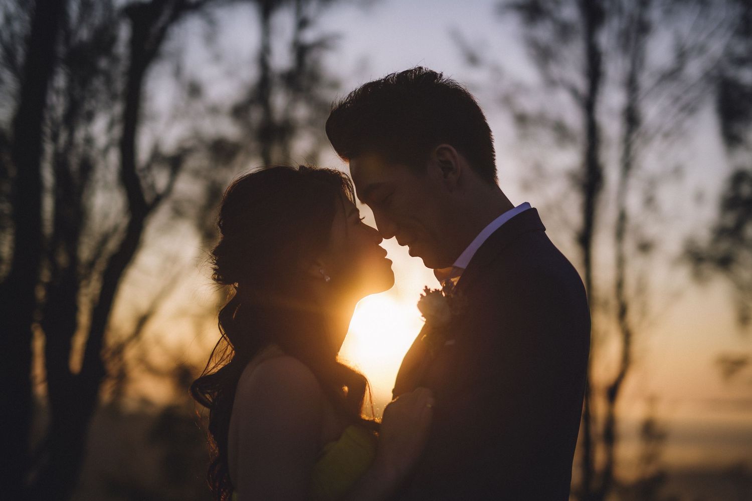 Silhouetted figures in an intimate moment with sun setting behind them.