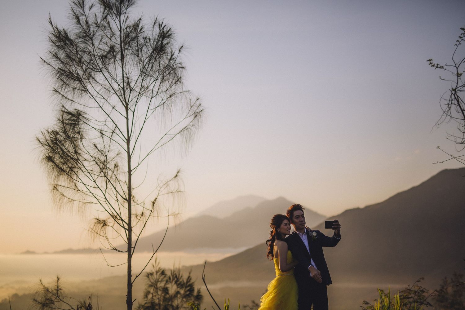 Scenic mountain vista with couple in silhouette during sunset.