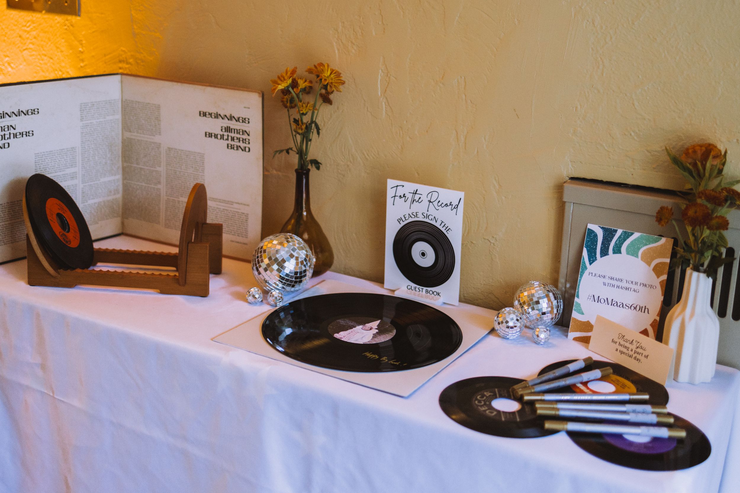 Event table setup with vinyl record decorations and party accessories.