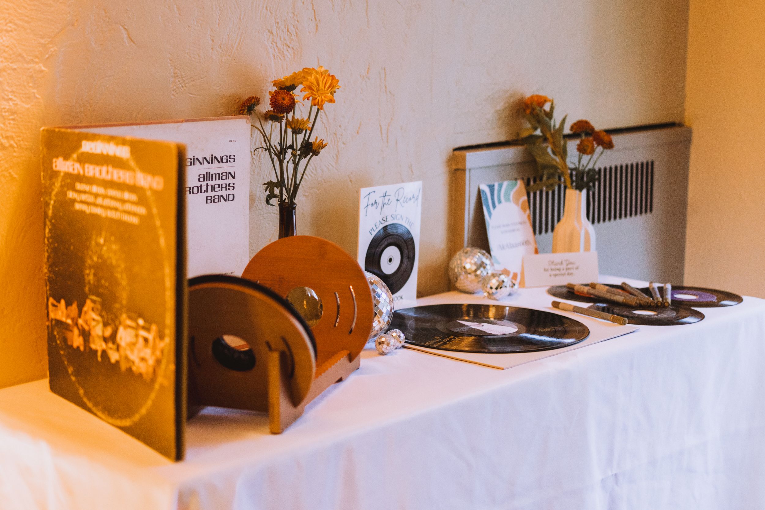 Vintage-themed party decor display with records and golden accents in warm lighting.