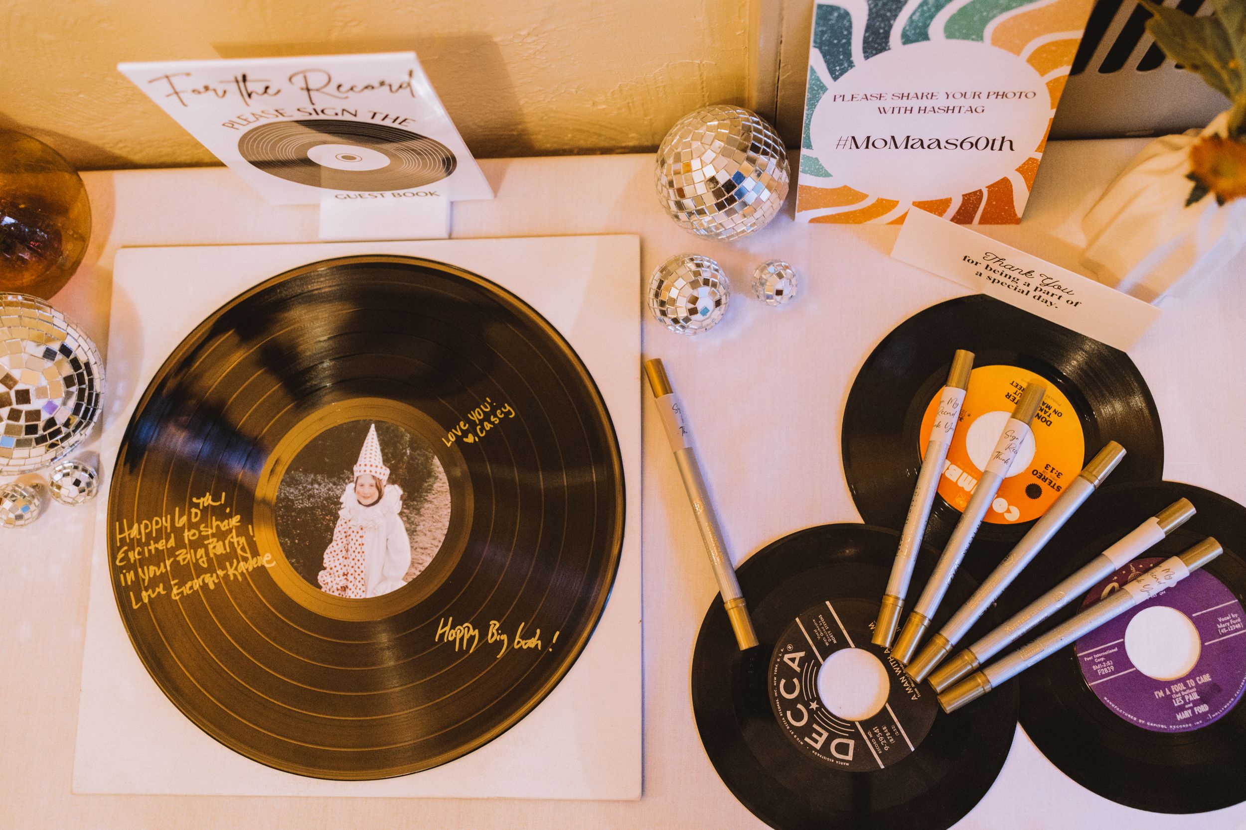 Vintage vinyl records and disco balls arranged on a table as retro party decorations.
