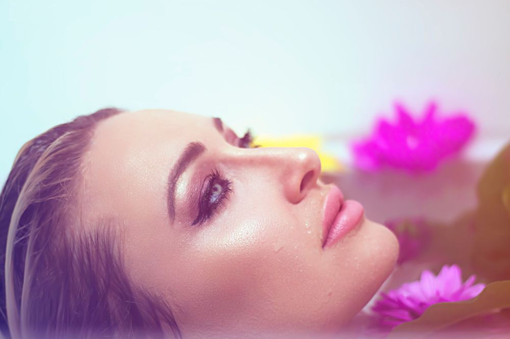 Dreamy portrait with soft focus and pink floral elements.