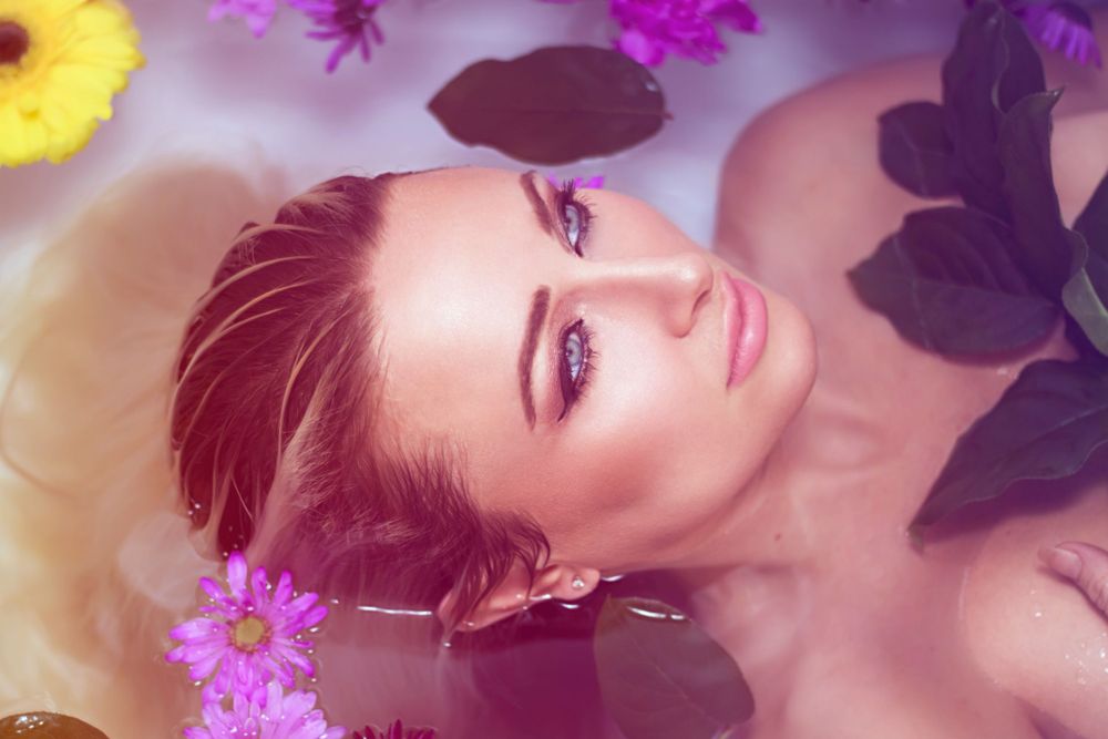 Ethereal beauty shot with colorful flowers and soft lighting effects.