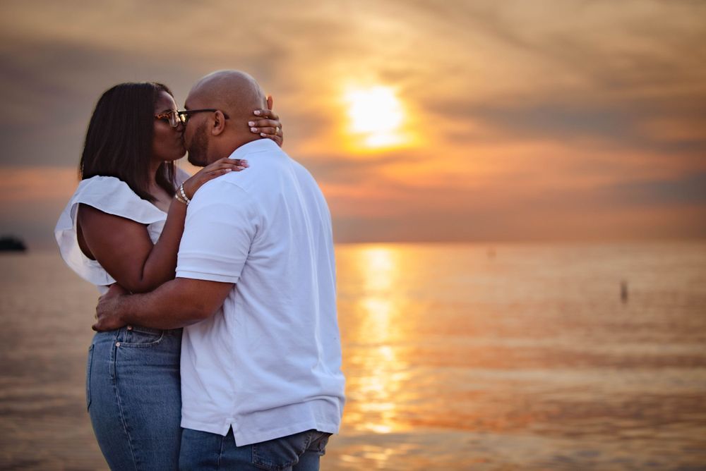Romantic couple embracing during golden sunset by the ocean.