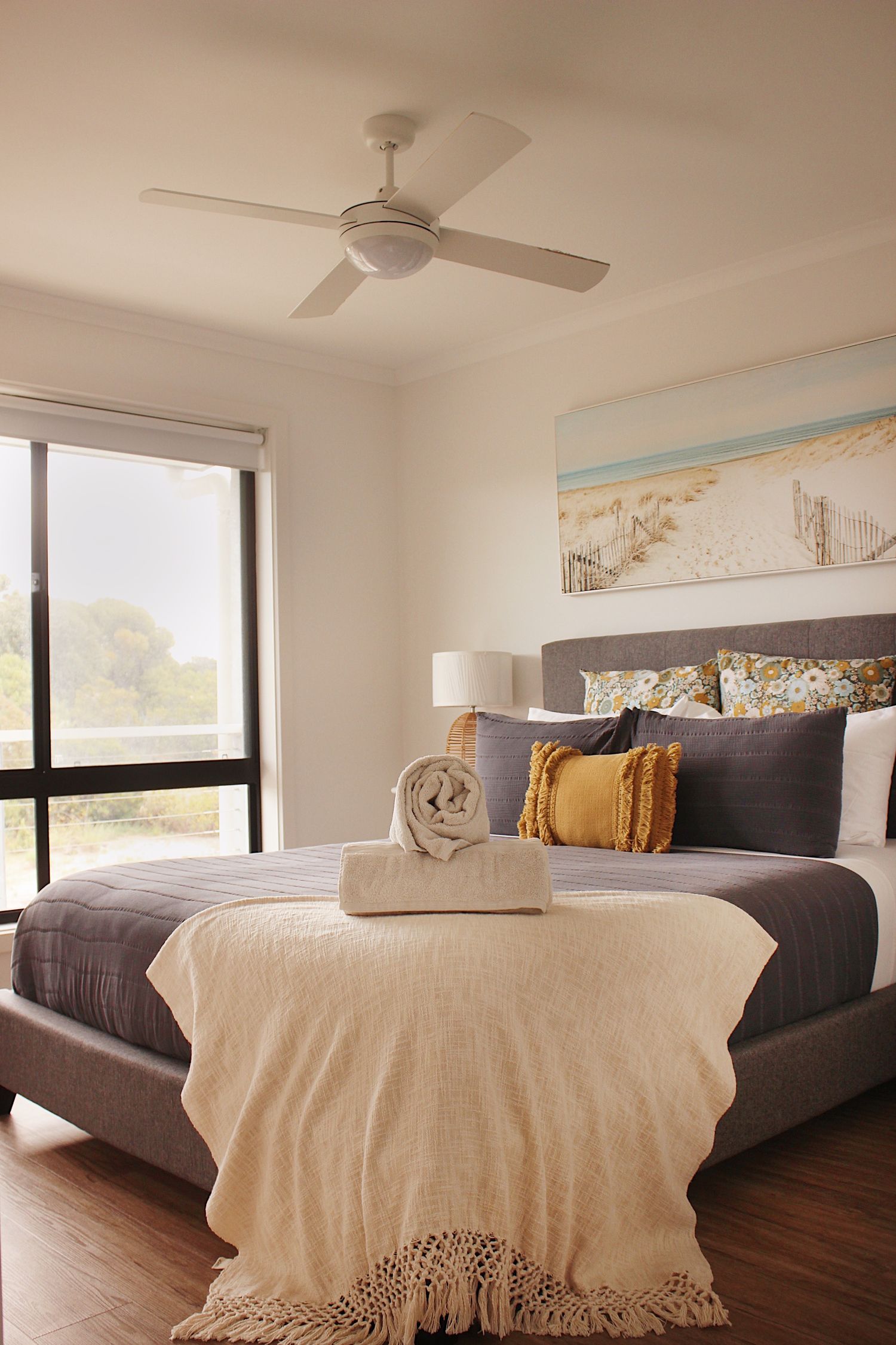 Modern bedroom with white bedding and dark wood floors.