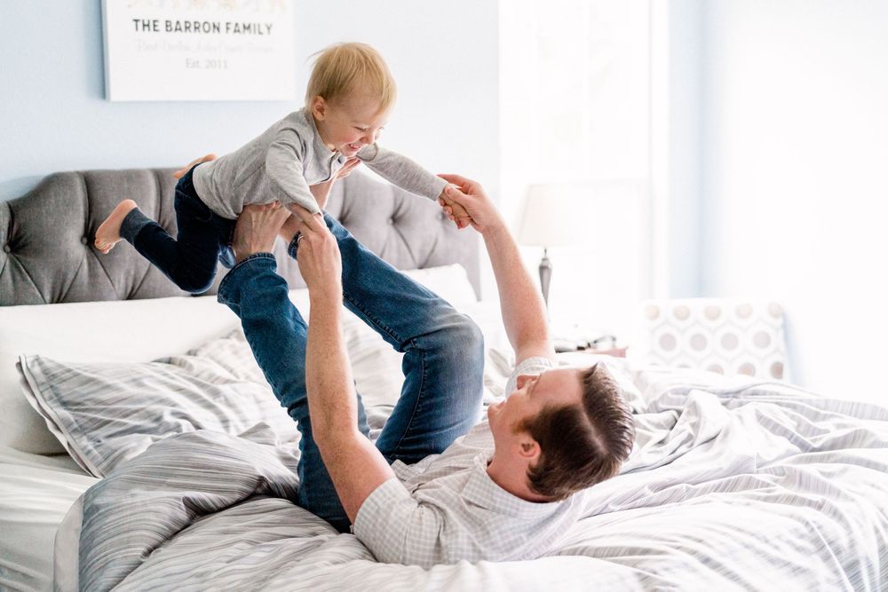 father and son playing on the bed lifestyle family session