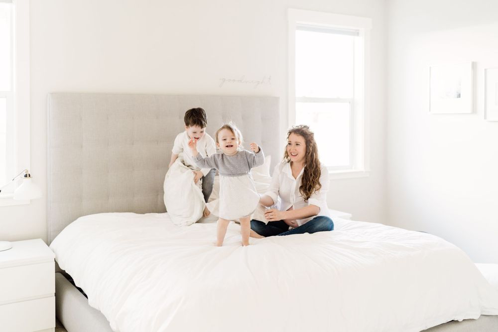 mama and kids playing on the bed family photos