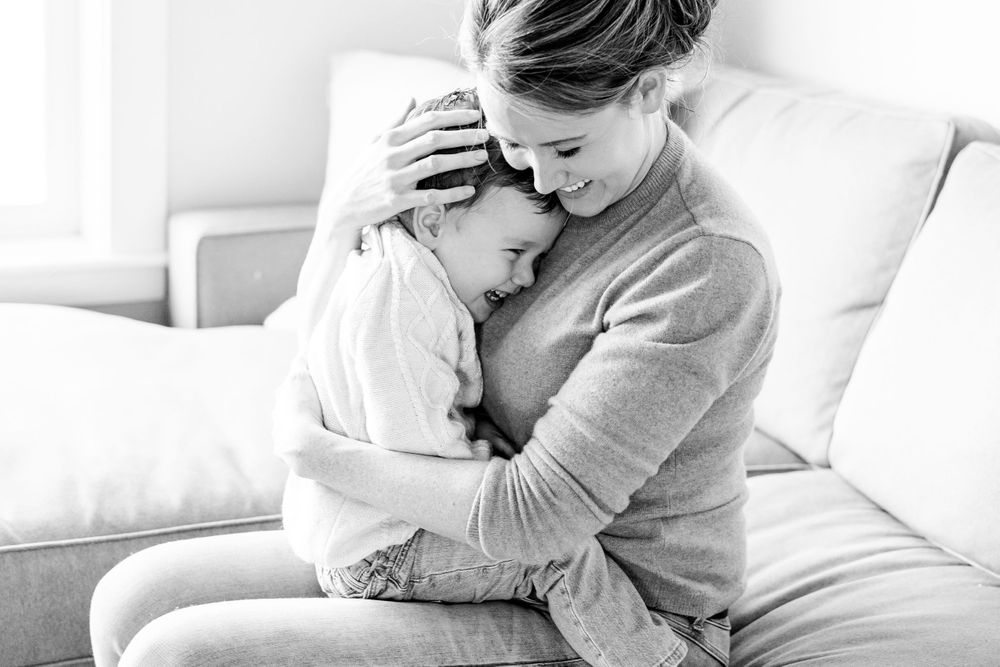 Mother hugging son while he laughs