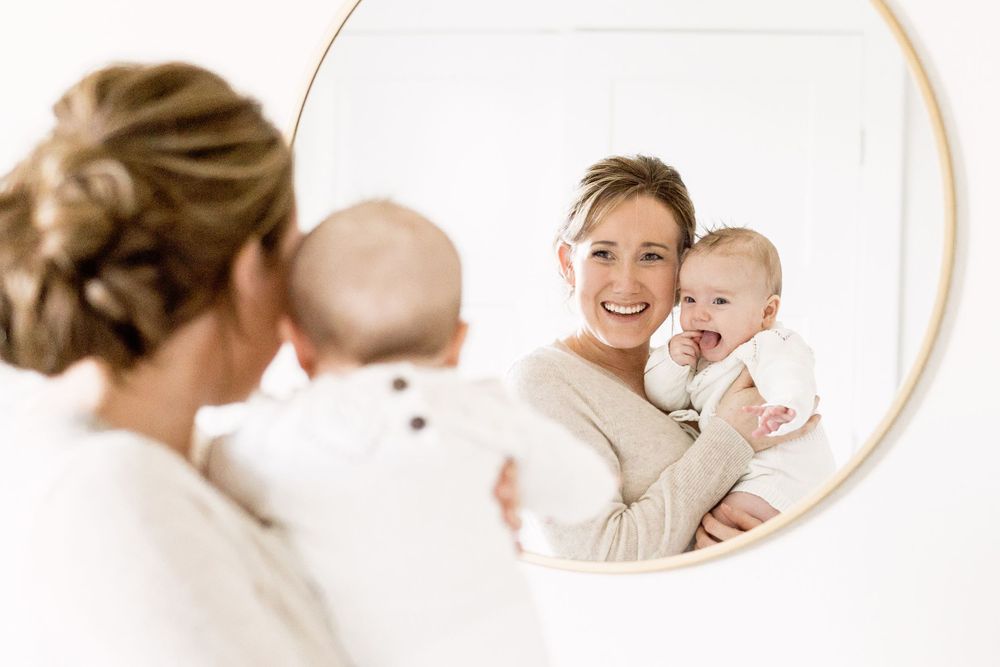 Mother and baby reflected in a round mirror
