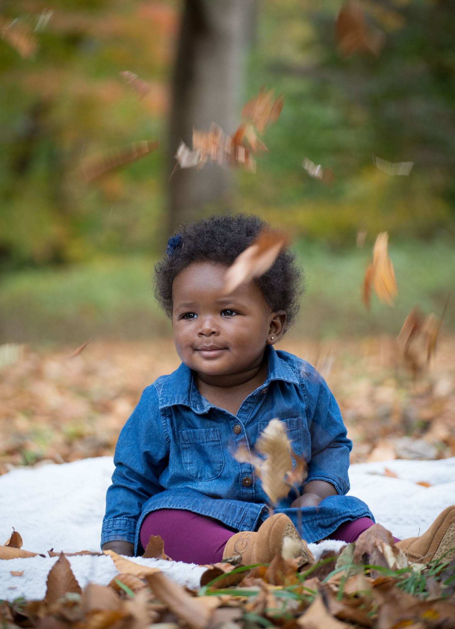DMV Black Female Photographer captures yearly family photos of a daughter smiling in a park with rustic leaves