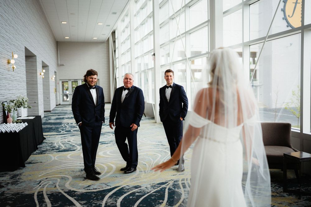 Wedding scene in a bright modern hallway with floor to ceiling windows.